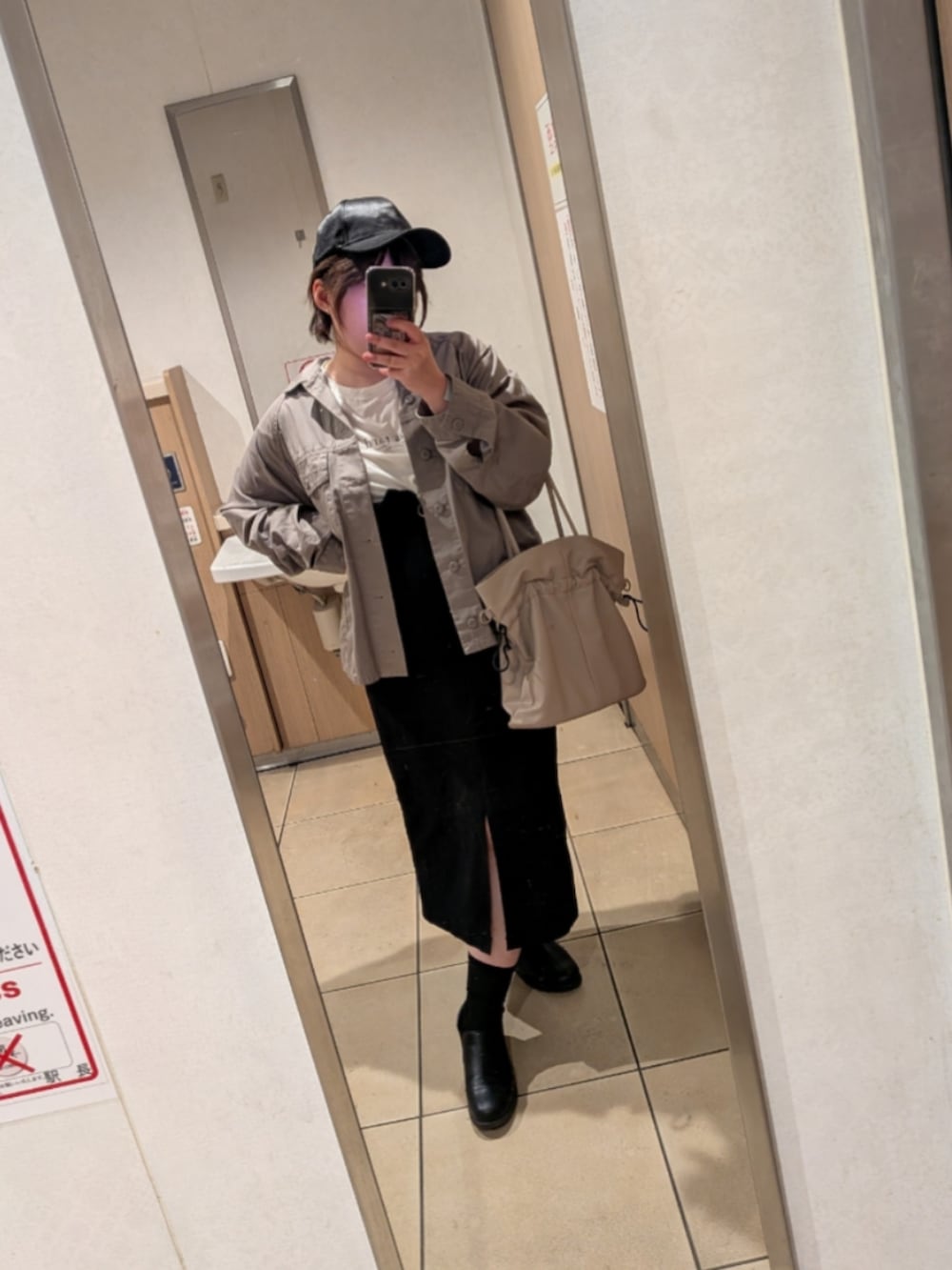 グレー系のブルゾン、ブラック系のジャンパースカート、ピンク系のハンドバッグを着用したレディースの春コーディネートの2枚目の写真