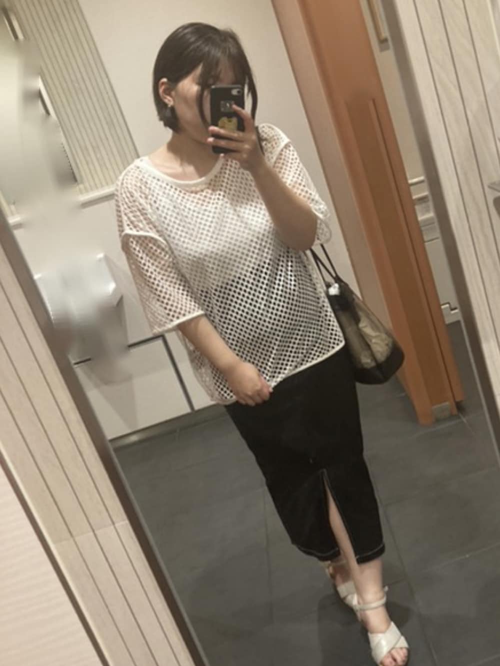 ブラック系のスカート、ホワイト系のTシャツ/カットソー、ブラック系のショルダーバッグを着用したレディースの夏コーディネートの2枚目の写真