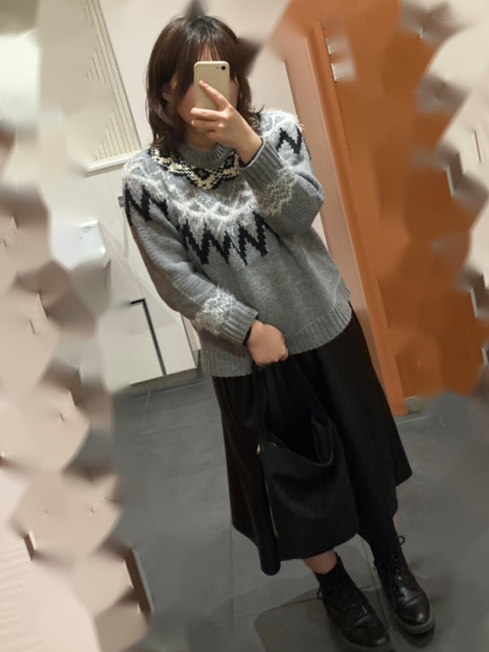 グレー系のニット/セーター、ブラック系のスカート、ブラック系のブーツを着用したレディースの冬コーディネートの3枚目の写真
