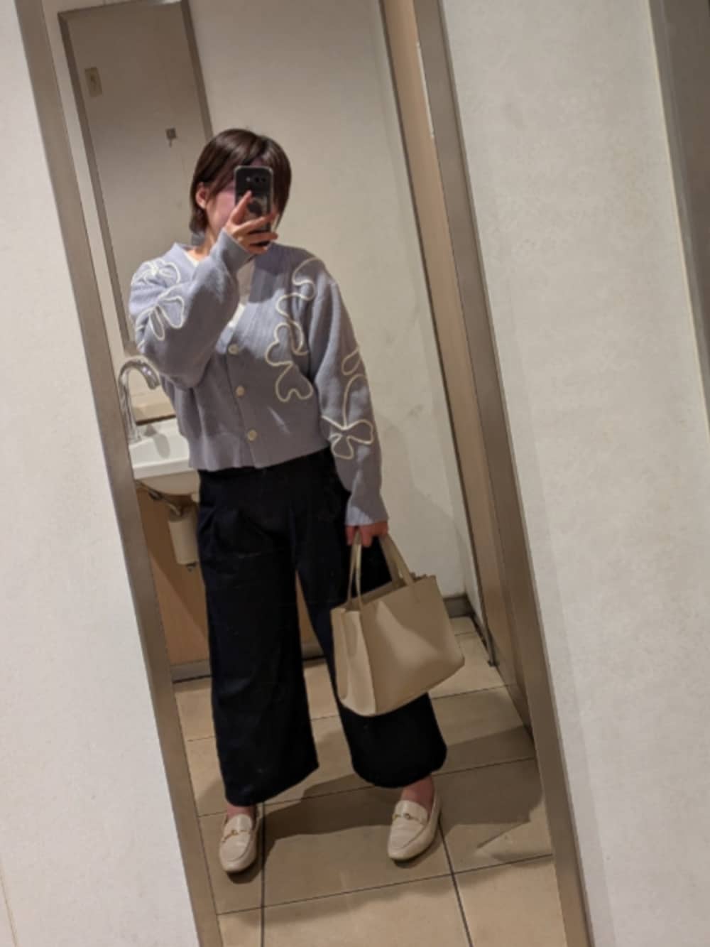 ブルー系のニット/セーター、グリーン系のTシャツ/カットソー、ベージュ系のショルダーバッグを着用したレディースの春コーディネートの2枚目の写真