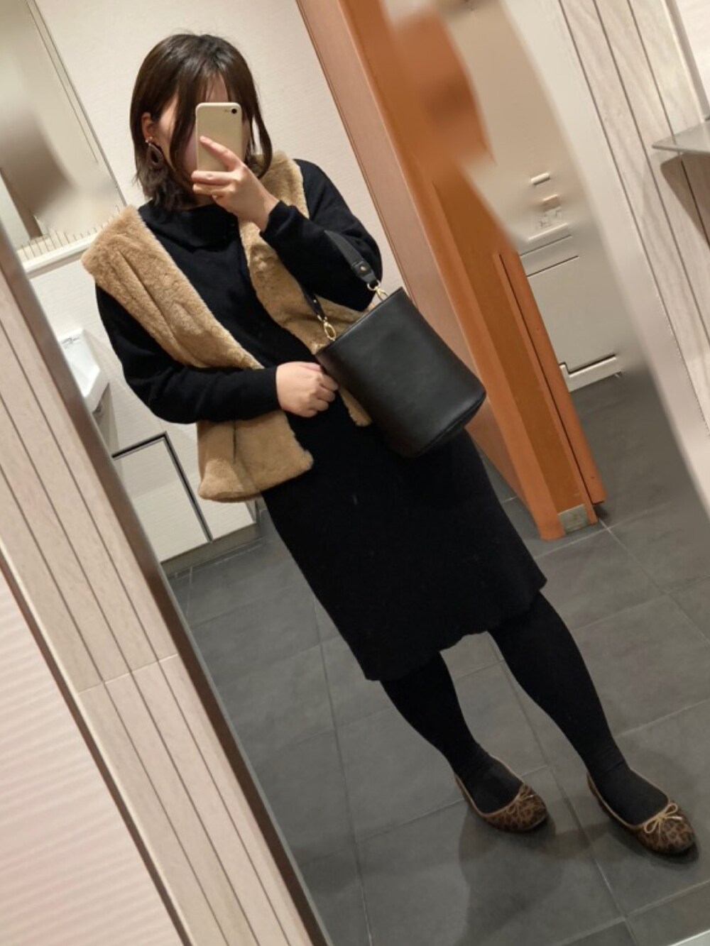 ブラウン系のブルゾン、ブラック系のワンピース、ブラウン系のバレエシューズを着用したレディースの冬コーディネートの2枚目の写真