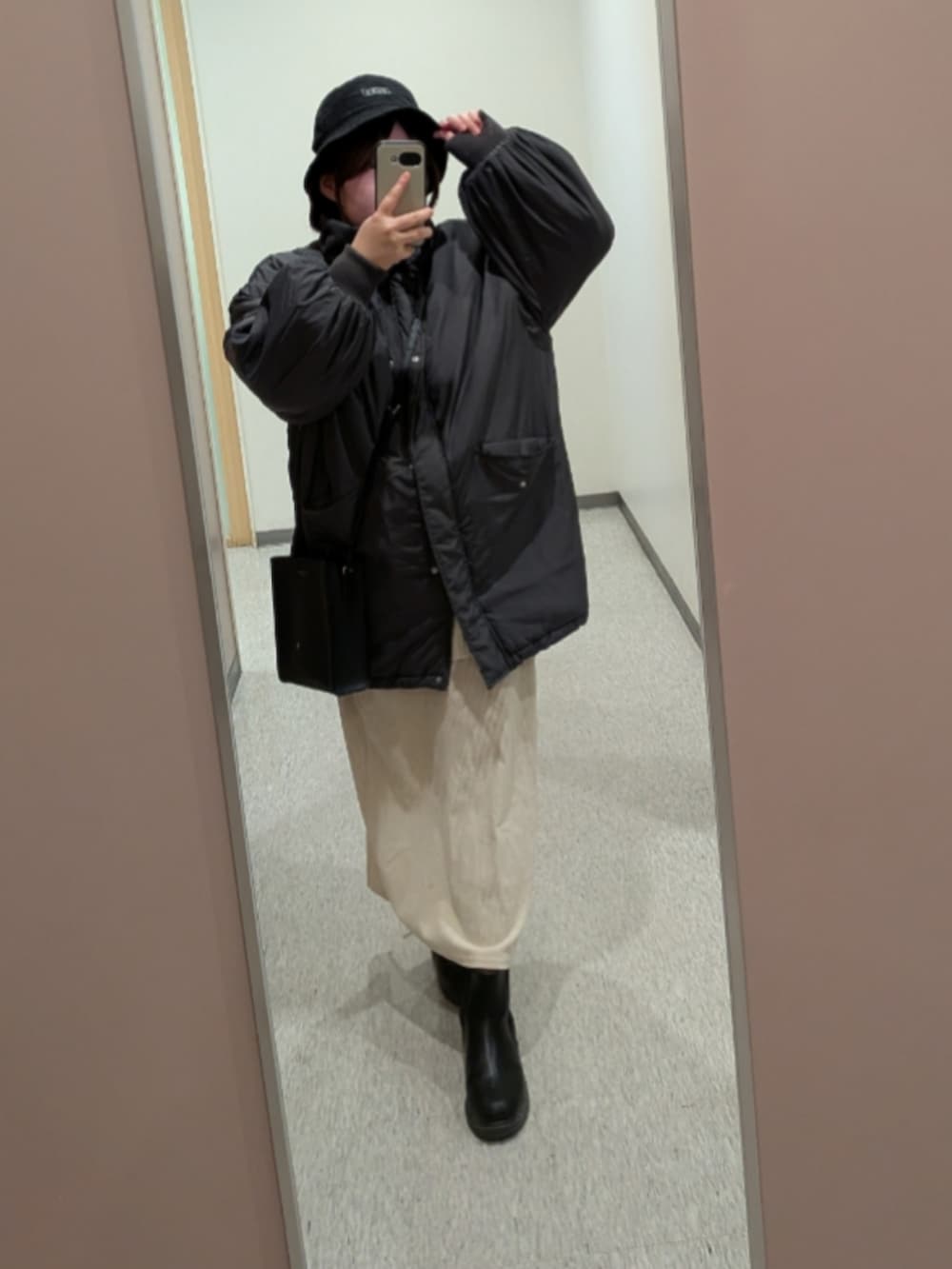 グレー系のジャケット/アウター、ホワイト系のスカート、ブラック系のショルダーバッグを着用したレディースの冬コーディネートの2枚目の写真