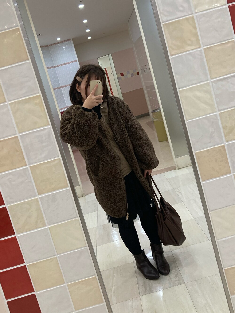 ブラウン系のブルゾン、ブラック系のスカート、ブラウン系のショルダーバッグを着用したレディースの秋コーディネートの2枚目の写真