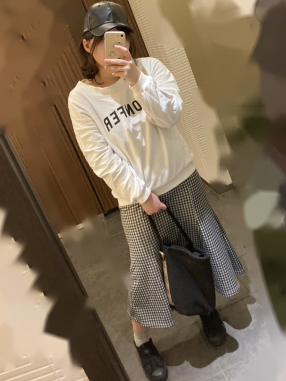 ホワイト系のスカート、グリーン系のマウンテンパーカー、ホワイト系のスウェットを着用したレディースの冬コーディネートの2枚目の写真