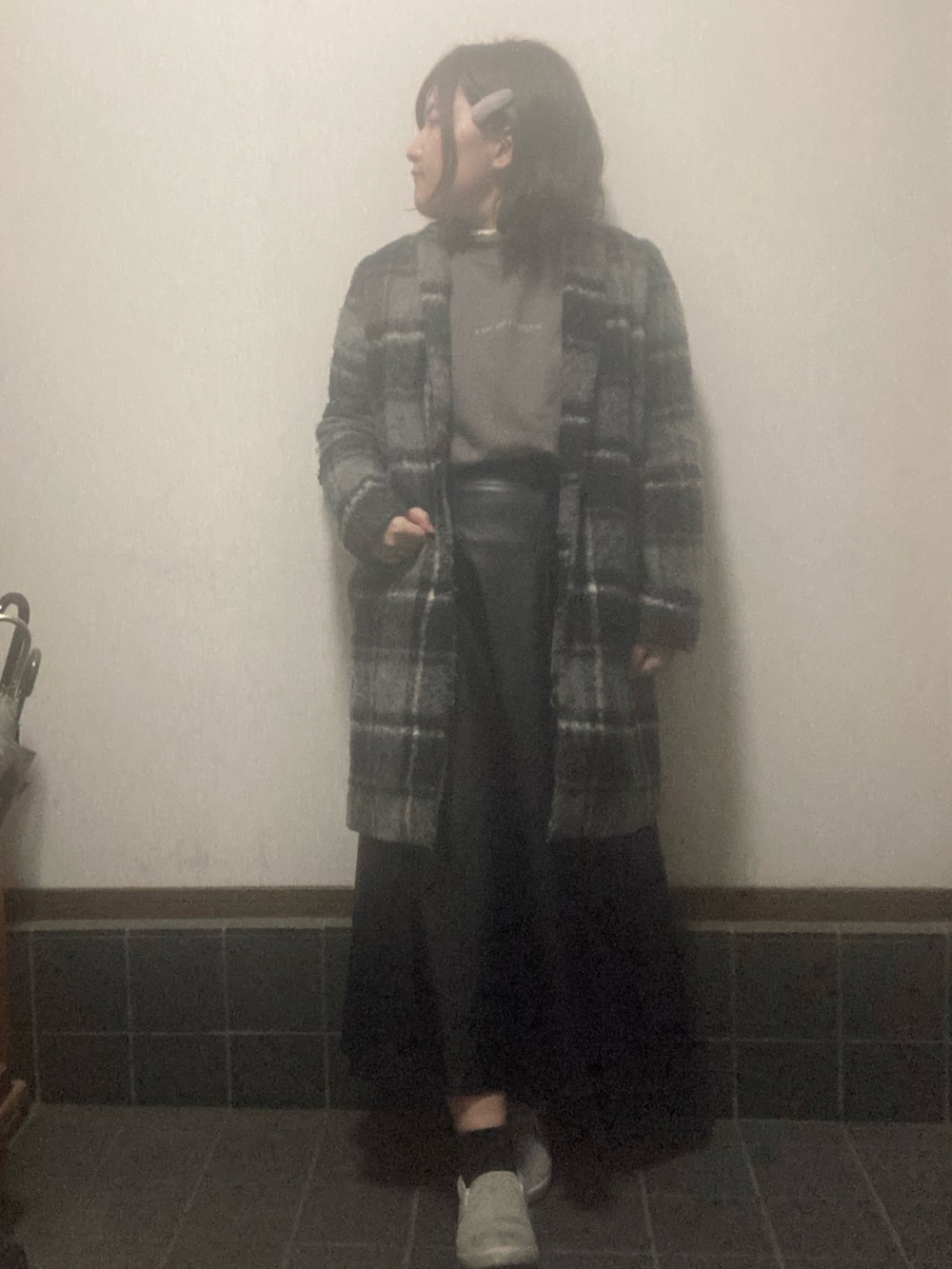 ブラック系のチェスターコート、グレー系のスウェット、ブラック系のスカートを着用したレディースの秋コーディネートの2枚目の写真