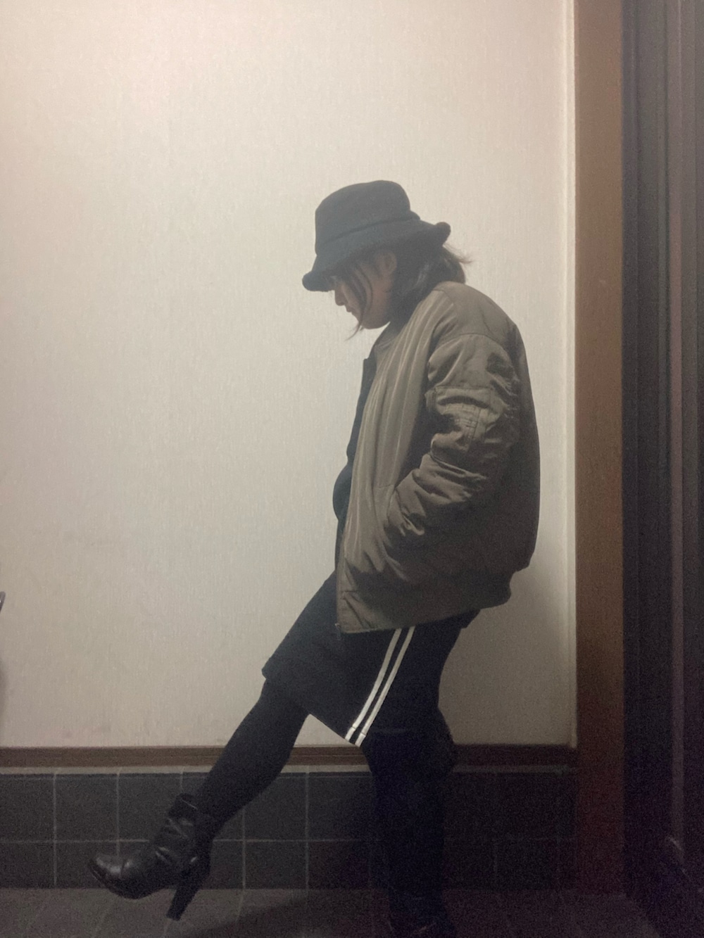 ブラック系のスウェット、ブラック系のスカート、ブラック系のブーツを着用したレディースの秋コーディネートの2枚目の写真