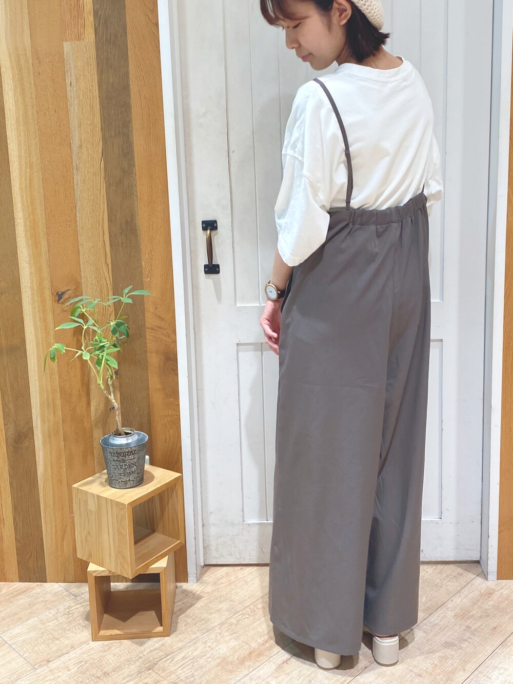 ホワイト系のサンダル、ホワイト系のTシャツ/カットソー、ブラウン系のサロペット/オーバーオールを着用したレディースの夏コーディネートの2枚目の写真