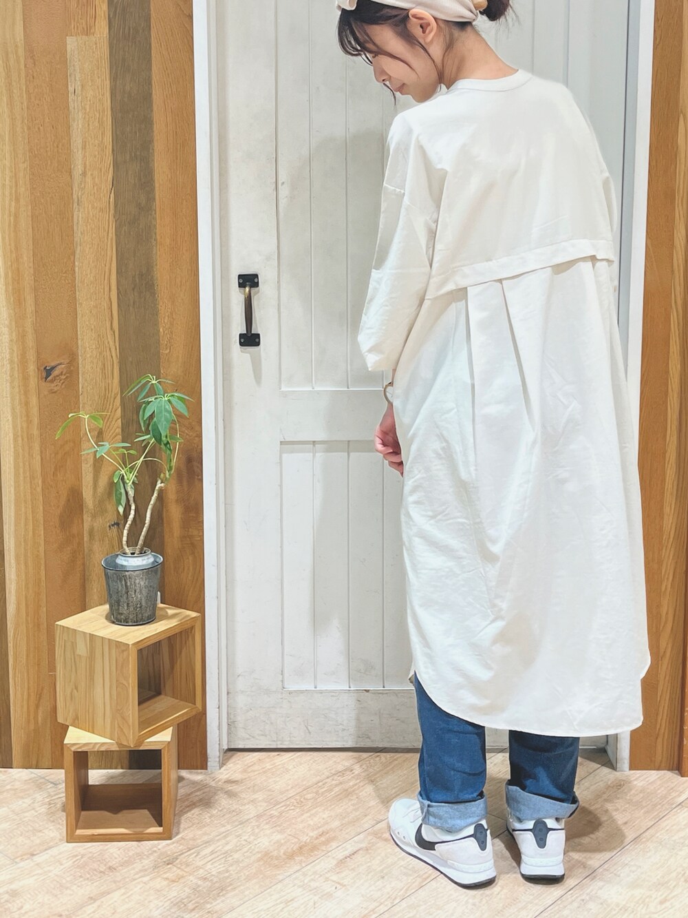 ホワイト系のワンピース、ブルー系のデニムパンツを着用したレディースの秋コーディネートの2枚目の写真