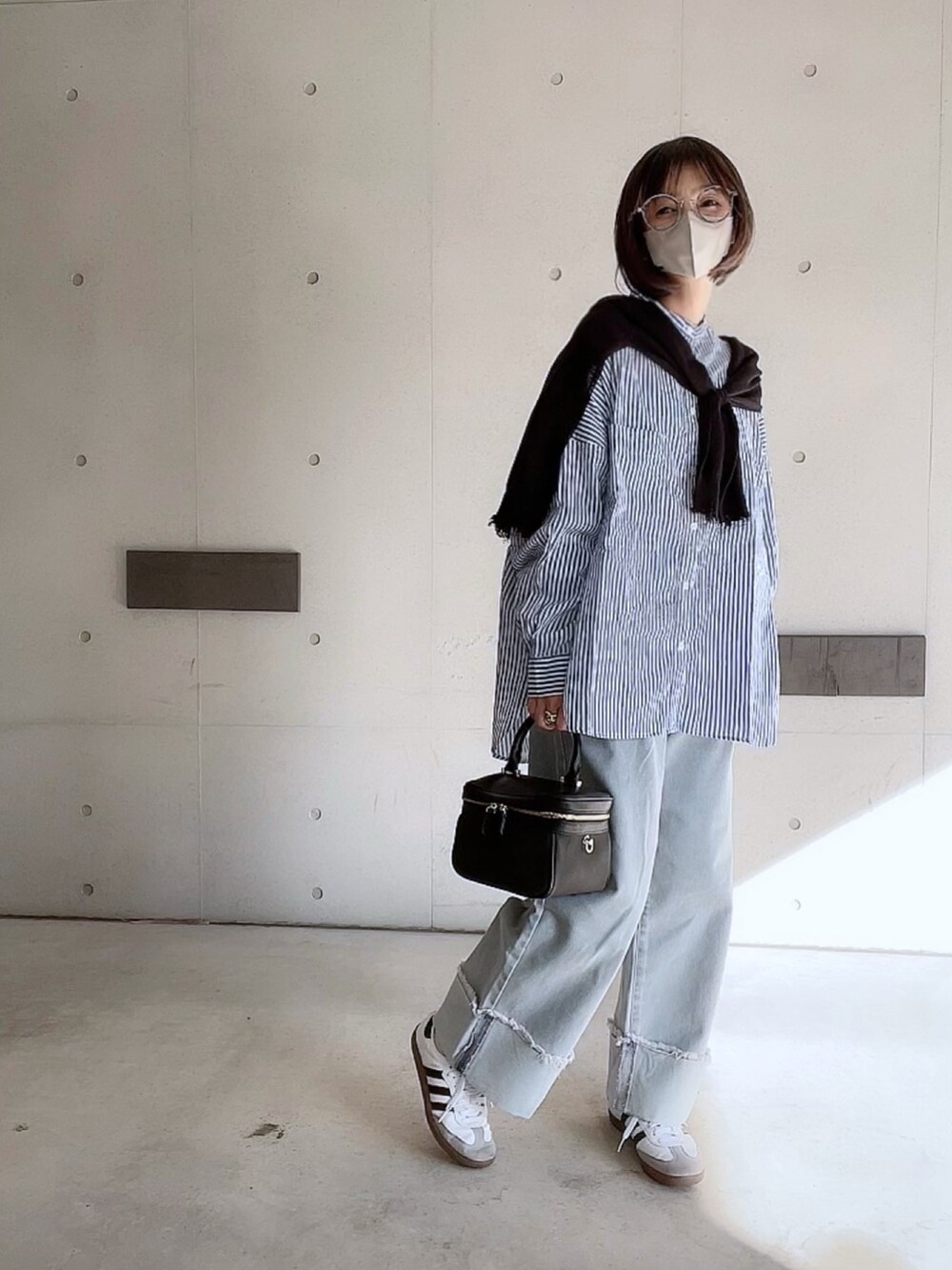 ブルー系のシャツ/ブラウス、ブルー系のデニムパンツ、ブラック系のショルダーバッグを着用したレディースの冬コーディネートの4枚目の写真