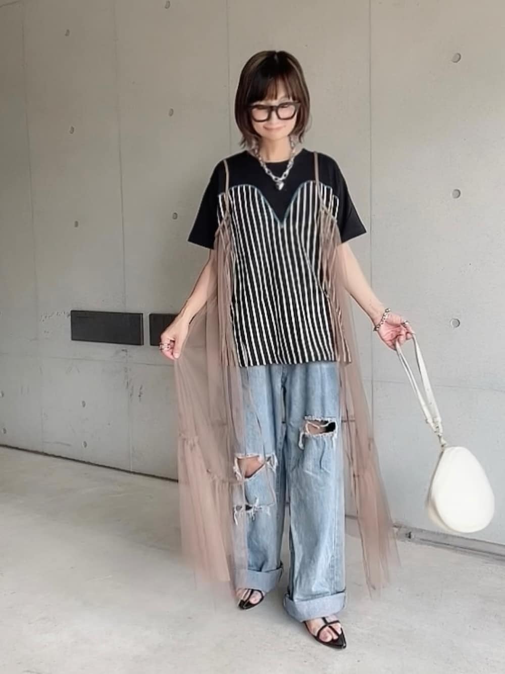 ブラック系のTシャツ/カットソー、ブルー系のデニムパンツ、ブラック系のサンダルを着用したレディースの夏コーディネートの2枚目の写真