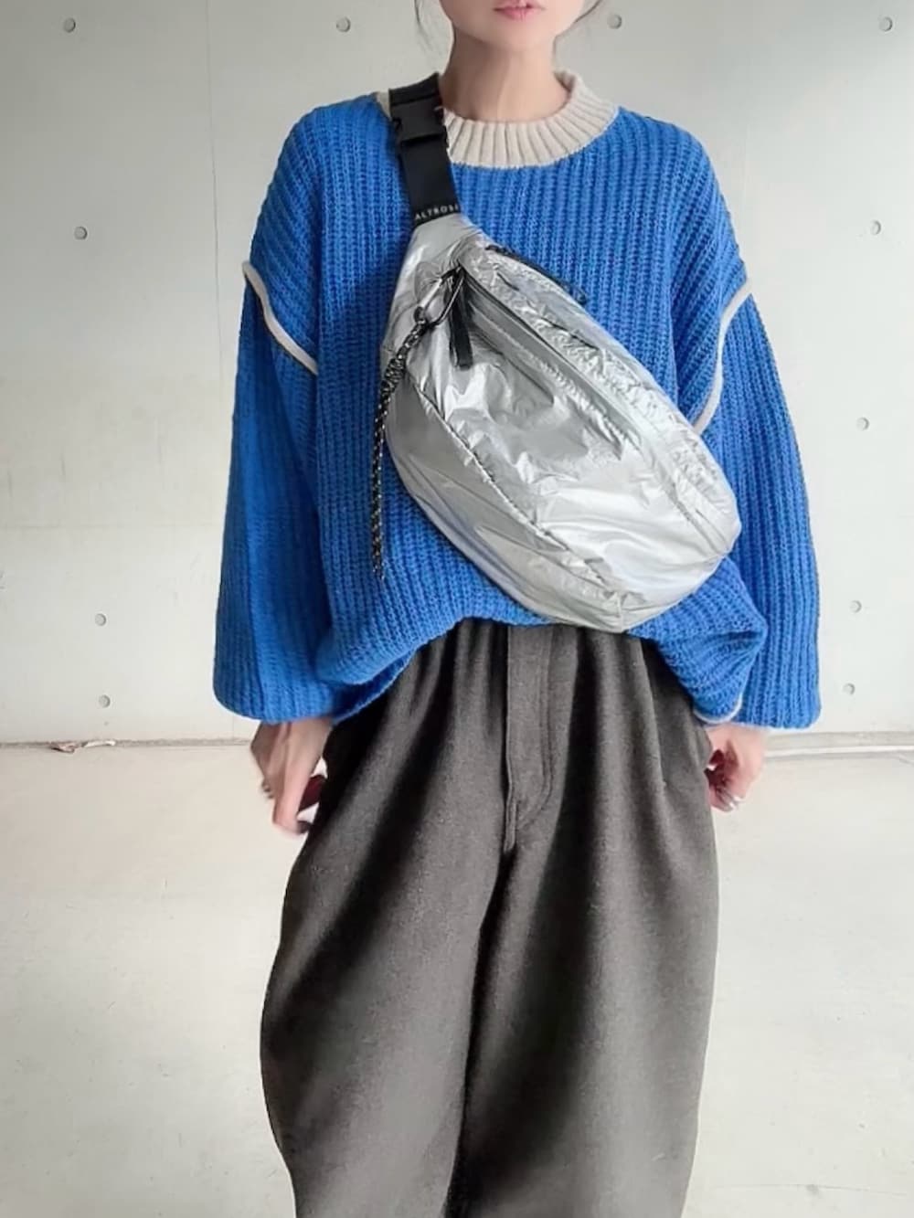 ブルー系のニット/セーター、シルバー系のボディバッグ/ウエストポーチ、ブルー系のスリッポンを着用したレディースの秋コーディネートの5枚目の写真