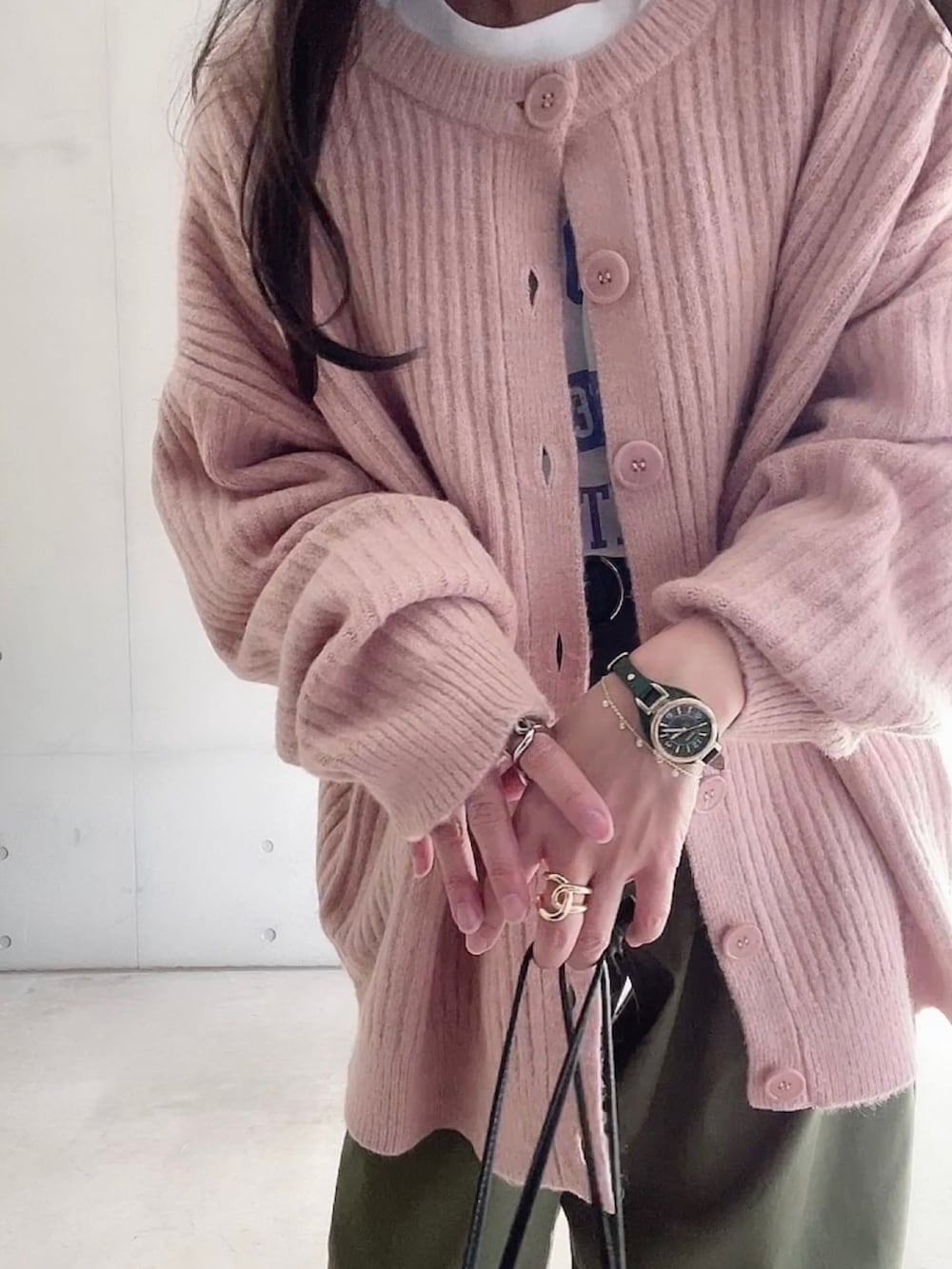 グリーン系のチノパンツ、ホワイト系のTシャツ/カットソー、ピンク系のカーディガン/ボレロを着用したレディースの秋コーディネートの2枚目の写真