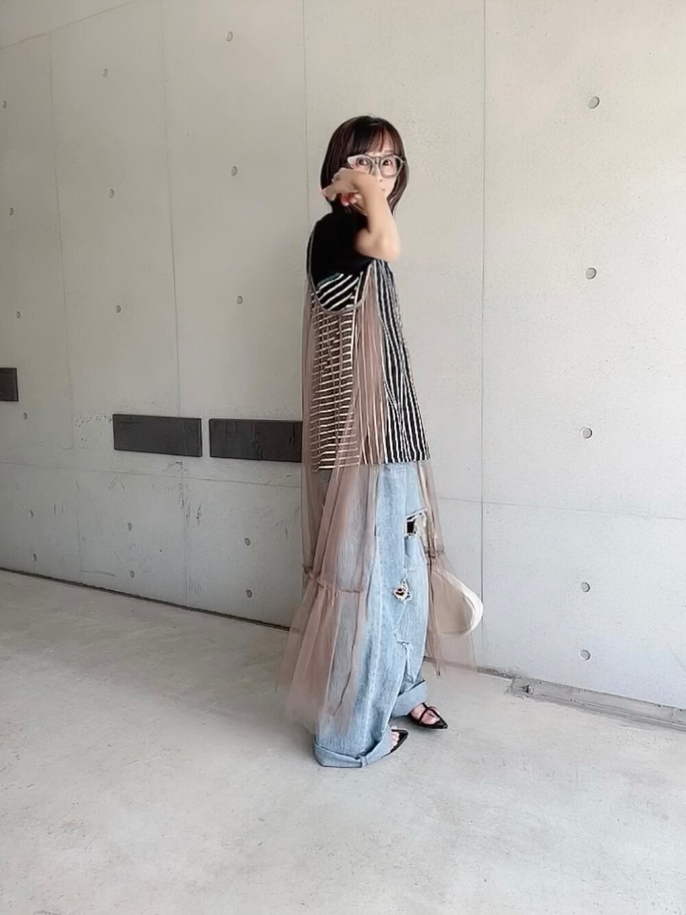 ブラック系のTシャツ/カットソー、ブルー系のデニムパンツ、ブラック系のサンダルを着用したレディースの夏コーディネートの3枚目の写真