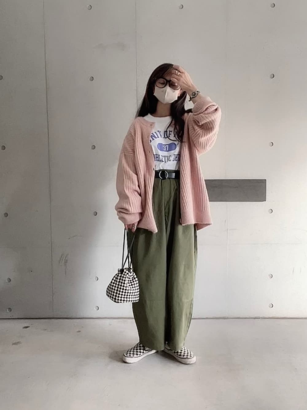 グリーン系のチノパンツ、ホワイト系のTシャツ/カットソー、ピンク系のカーディガン/ボレロを着用したレディースの秋コーディネートの5枚目の写真