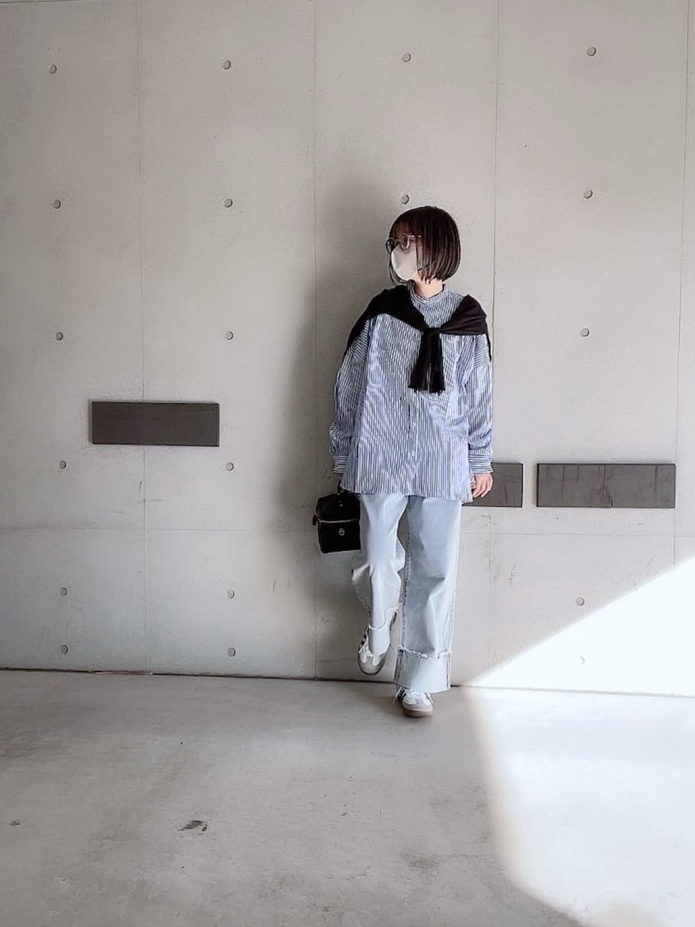 ブルー系のシャツ/ブラウス、ブルー系のデニムパンツ、ブラック系のショルダーバッグを着用したレディースの冬コーディネートの3枚目の写真