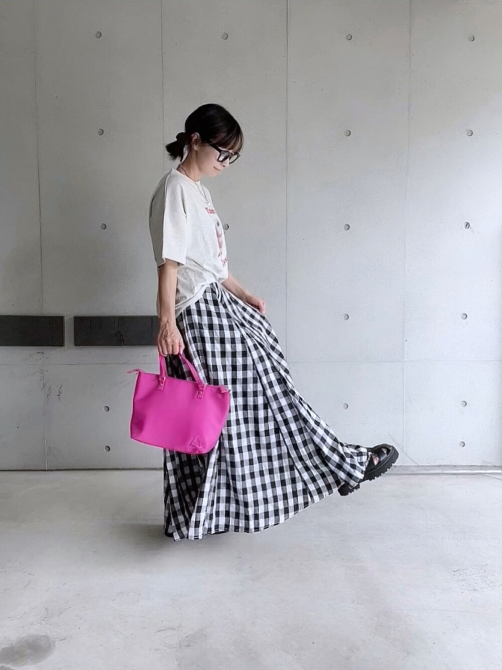 ベージュ系のTシャツ/カットソー、ブラック系のスカート、ピンク系のトートバッグを着用したレディースの夏コーディネートの3枚目の写真
