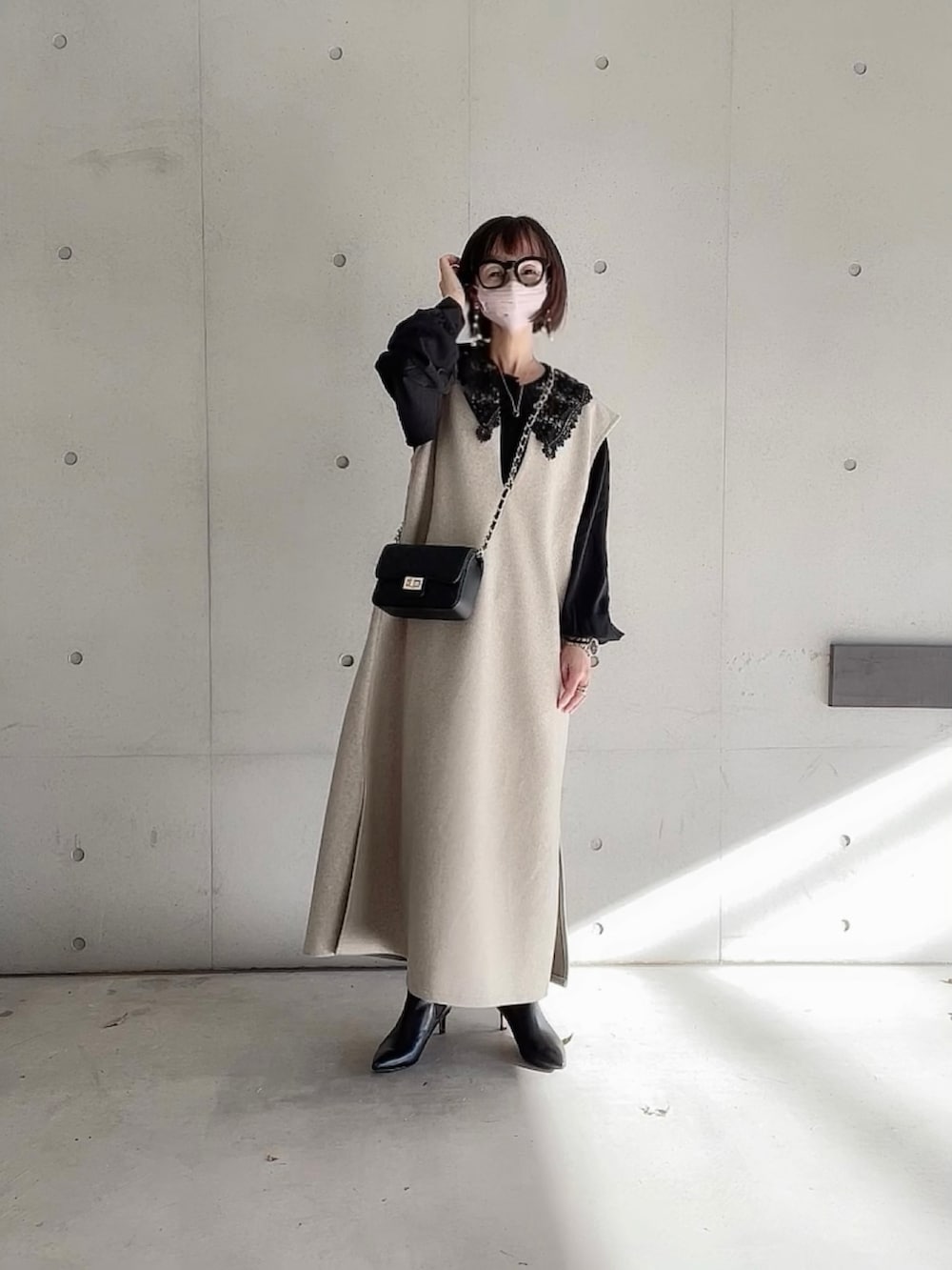 ベージュ系のワンピース、ブラック系のシャツ/ブラウス、ブラック系のブーツを着用したレディースの冬コーディネートの3枚目の写真