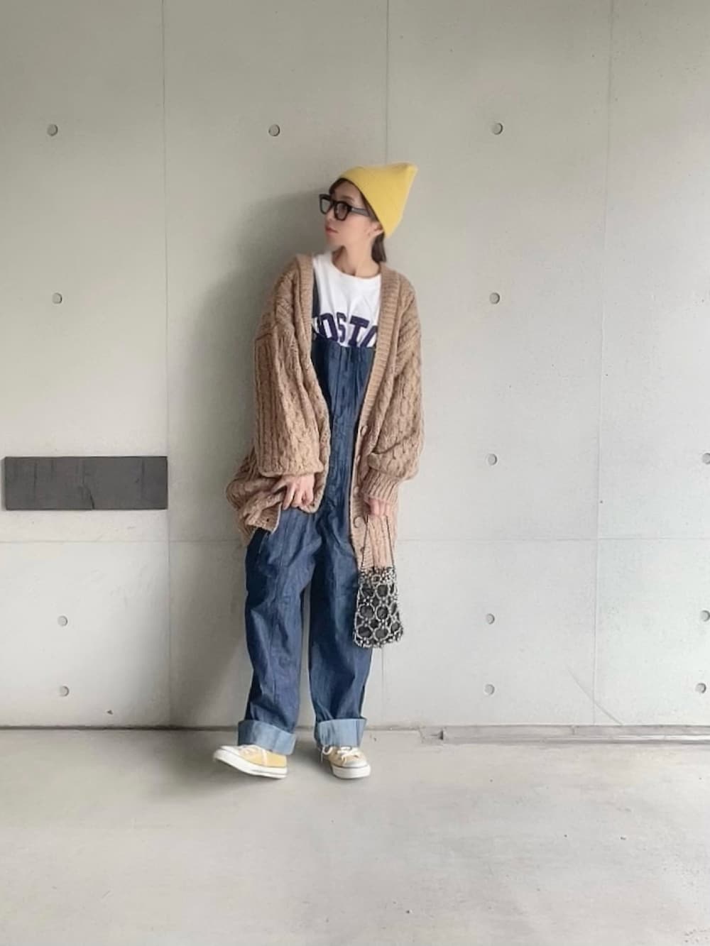 ブラウン系のカーディガン/ボレロ、ホワイト系のTシャツ/カットソー、ブルー系のサロペット/オーバーオールを着用したレディースの秋コーディネートの4枚目の写真