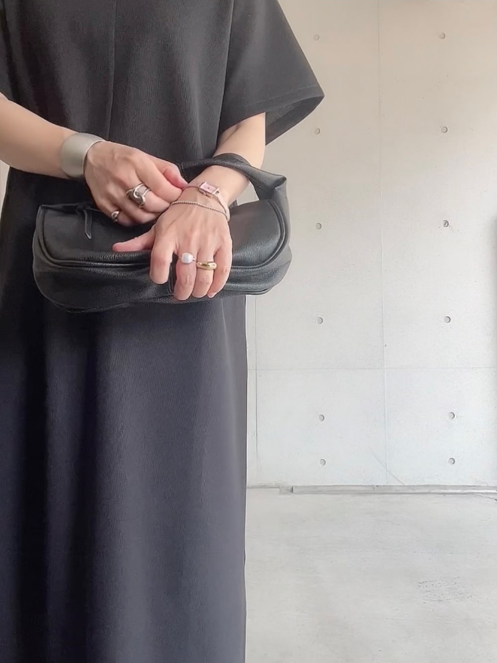 ブラック系のワンピース、ブラック系のハンドバッグ、ブラック系のサンダルを着用したレディースの夏コーディネートの4枚目の写真