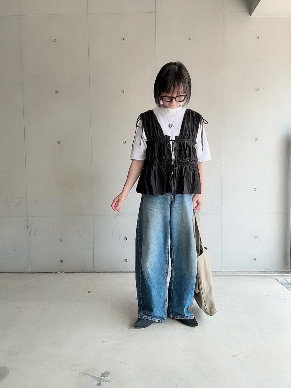ブラック系のシャツ/ブラウス、ブルー系のデニムパンツ、ブラック系のパンプスを着用したレディースの夏コーディネートの2枚目の写真