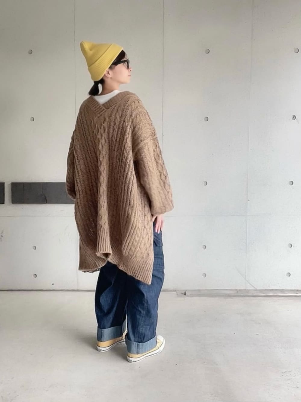 ブラウン系のカーディガン/ボレロ、ホワイト系のTシャツ/カットソー、ブルー系のサロペット/オーバーオールを着用したレディースの秋コーディネートの3枚目の写真