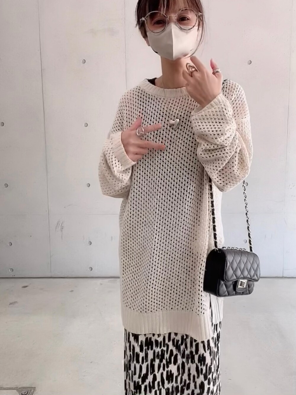 ホワイト系のニット/セーター、ホワイト系のスカート、ブラック系のショルダーバッグを着用したレディースの春コーディネートの5枚目の写真