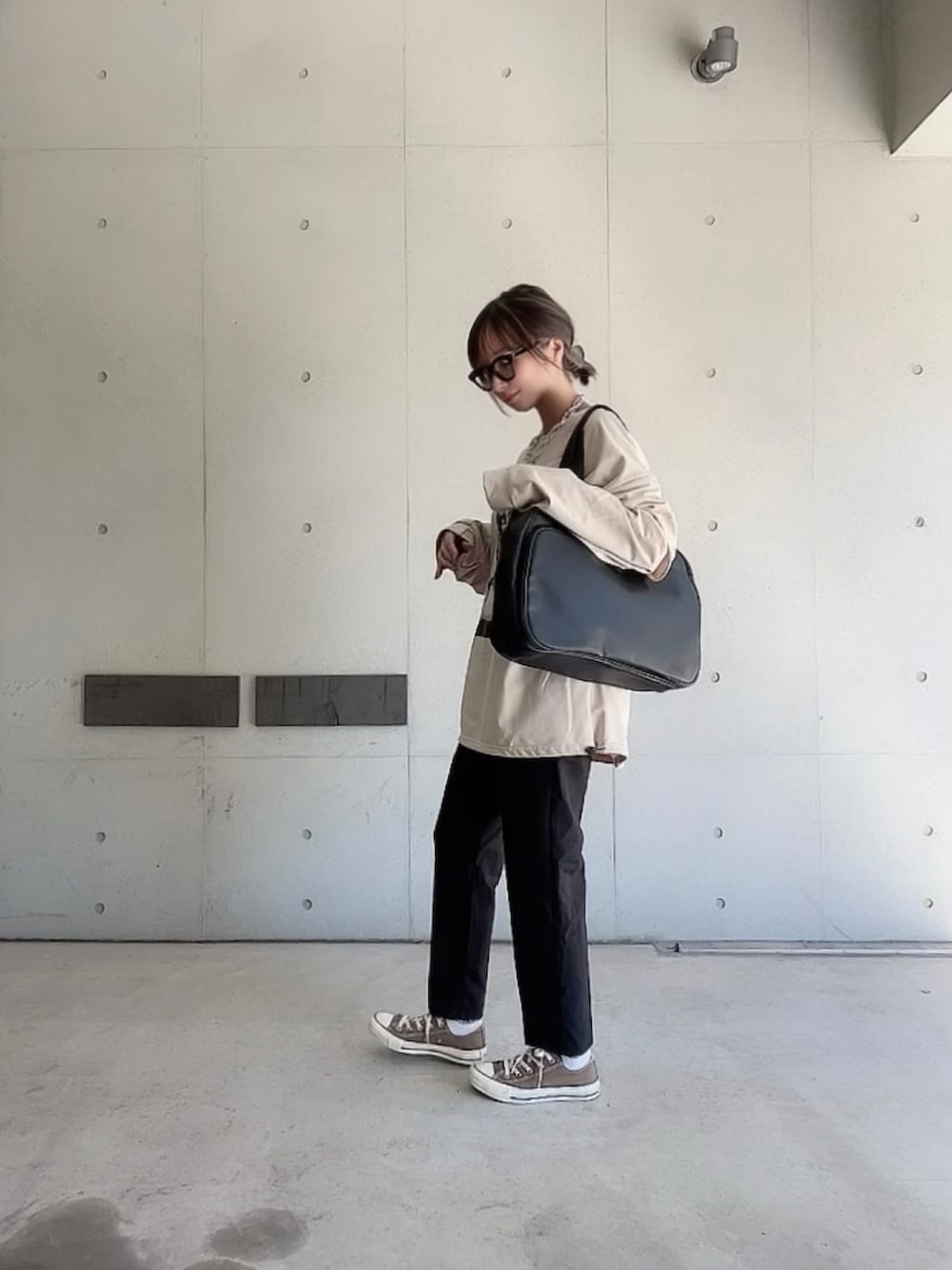 ブラック系のその他パンツ、ブラック系のボストンバッグ、ベージュ系のTシャツ/カットソーを着用したレディースの秋コーディネートの3枚目の写真