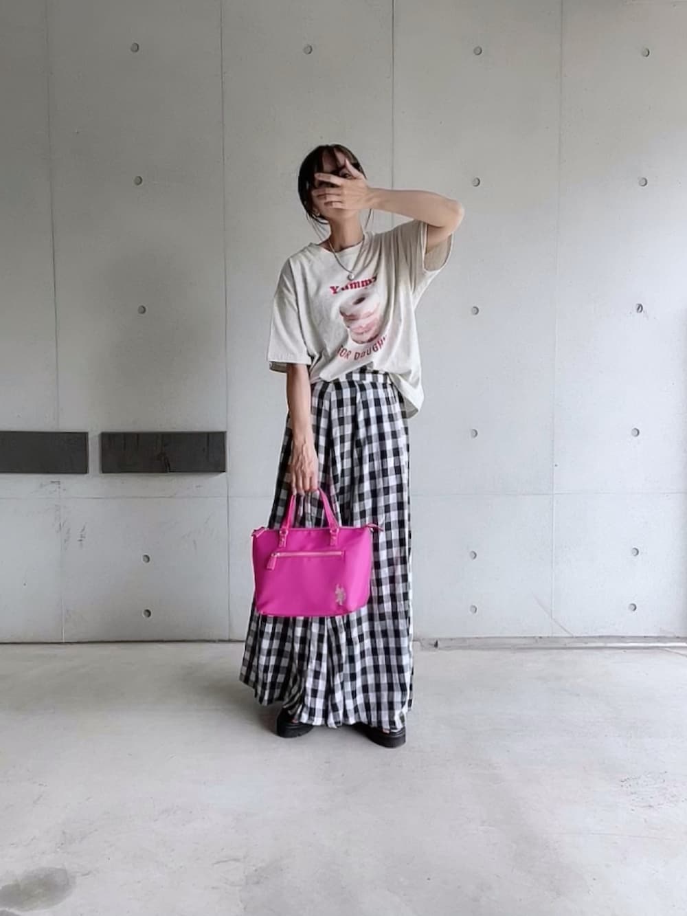 ベージュ系のTシャツ/カットソー、ブラック系のスカート、ピンク系のトートバッグを着用したレディースの夏コーディネートの2枚目の写真