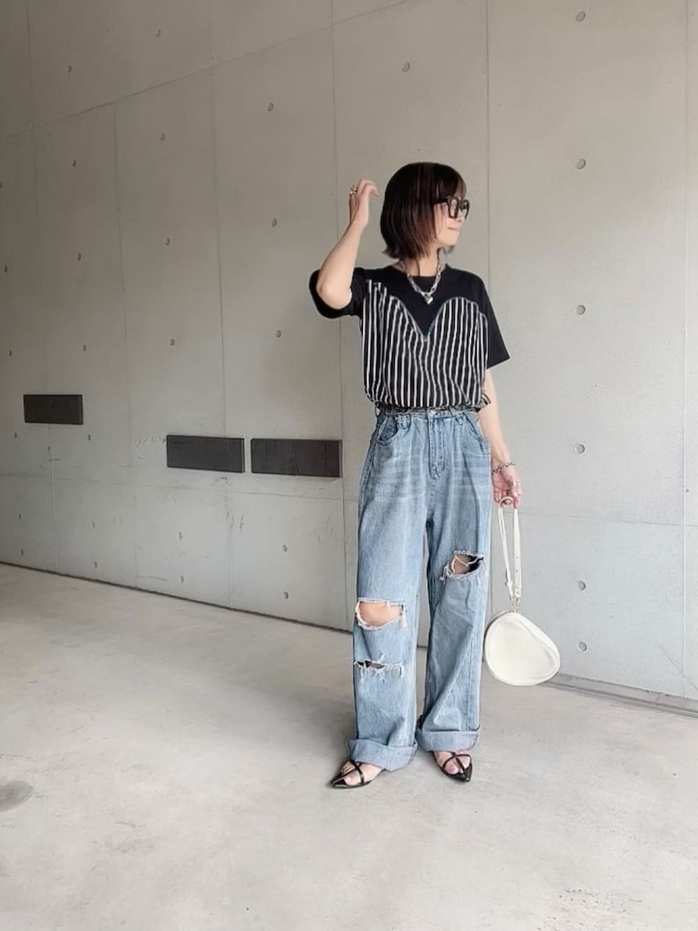 ブラック系のTシャツ/カットソー、ブルー系のデニムパンツ、ブラック系のサンダルを着用したレディースの夏コーディネートの4枚目の写真