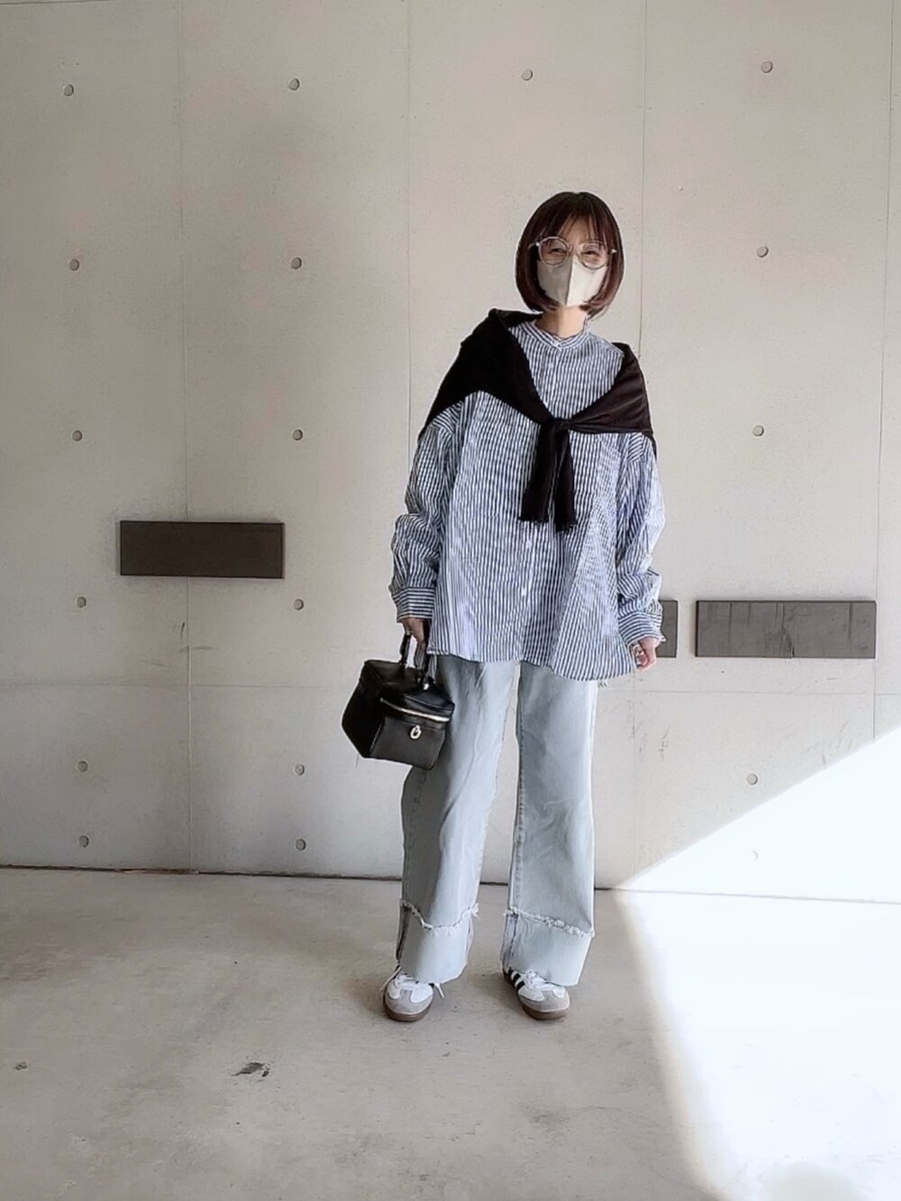 ブルー系のシャツ/ブラウス、ブルー系のデニムパンツ、ブラック系のショルダーバッグを着用したレディースの冬コーディネートの2枚目の写真