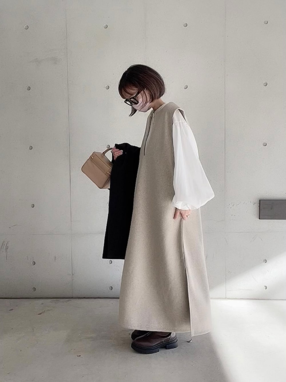 ベージュ系のワンピース、ホワイト系のシャツ/ブラウス、ブラウン系のブーツを着用したレディースの冬コーディネートの5枚目の写真