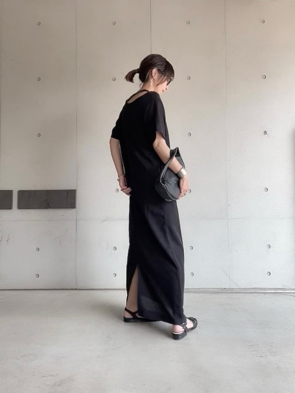 ブラック系のワンピース、ブラック系のハンドバッグ、ブラック系のサンダルを着用したレディースの夏コーディネートの3枚目の写真