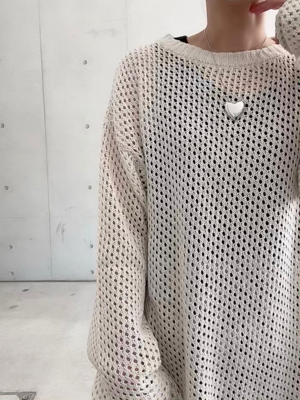 ホワイト系のニット/セーター、ホワイト系のスカート、ブラック系のショルダーバッグを着用したレディースの春コーディネートの4枚目の写真