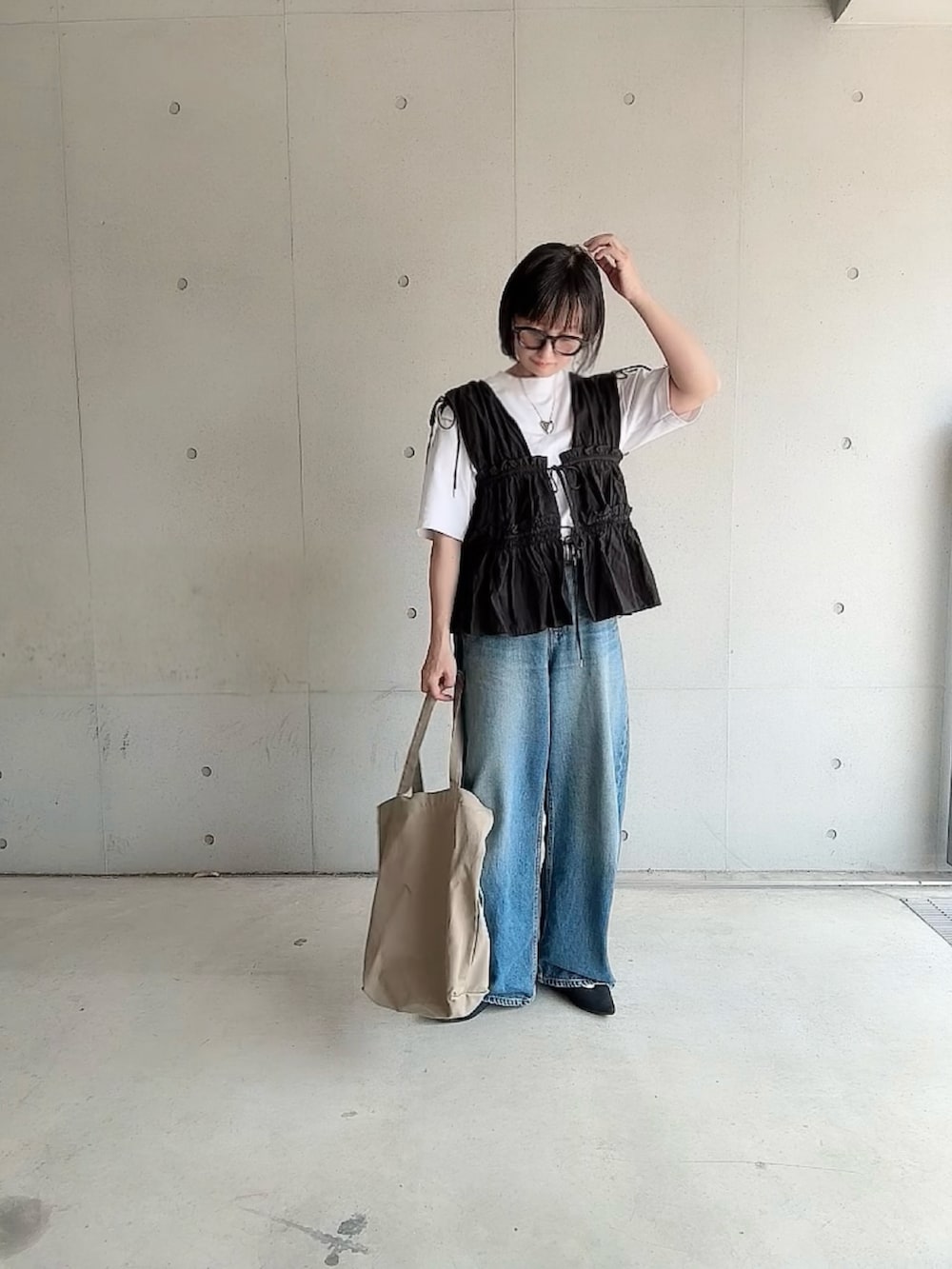 ブラック系のシャツ/ブラウス、ブルー系のデニムパンツ、ブラック系のパンプスを着用したレディースの夏コーディネートの5枚目の写真