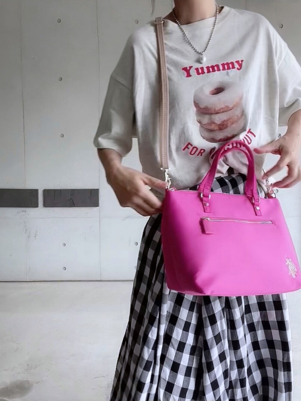 ベージュ系のTシャツ/カットソー、ブラック系のスカート、ピンク系のトートバッグを着用したレディースの夏コーディネートの4枚目の写真