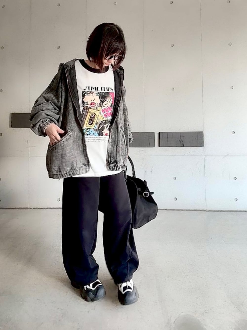 ホワイト系のTシャツ/カットソー、ブラック系のパンツ、ブラック系のスニーカーを着用したレディースの春コーディネートの3枚目の写真