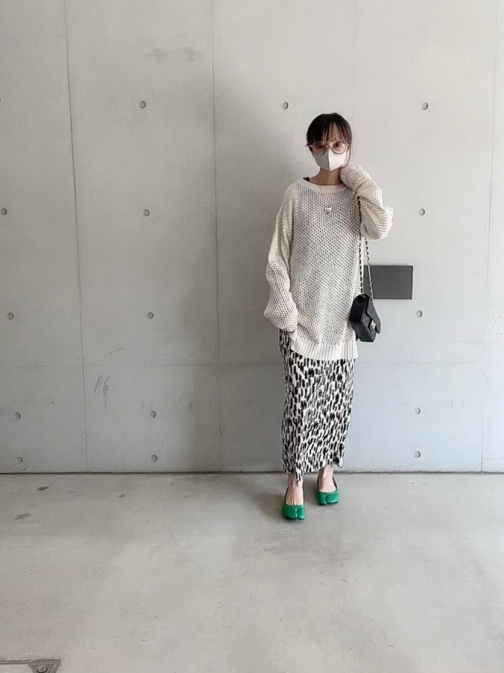 ホワイト系のニット/セーター、ホワイト系のスカート、ブラック系のショルダーバッグを着用したレディースの春コーディネートの3枚目の写真