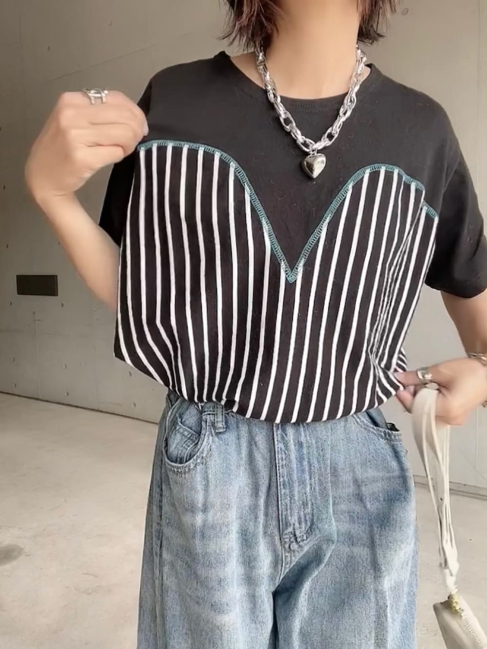 ブラック系のTシャツ/カットソー、ブルー系のデニムパンツ、ブラック系のサンダルを着用したレディースの夏コーディネートの5枚目の写真