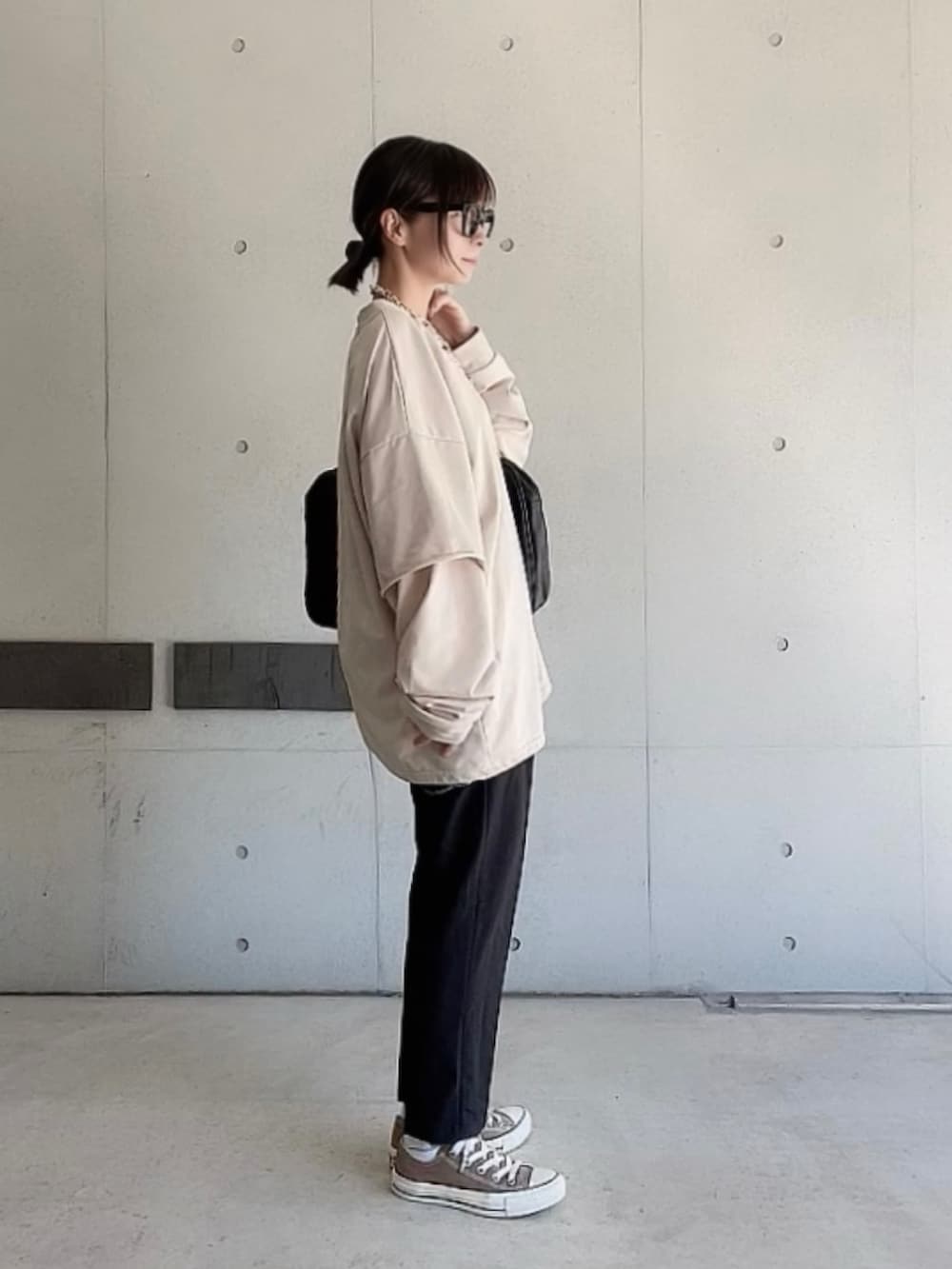 ブラック系のその他パンツ、ブラック系のボストンバッグ、ベージュ系のTシャツ/カットソーを着用したレディースの秋コーディネートの2枚目の写真