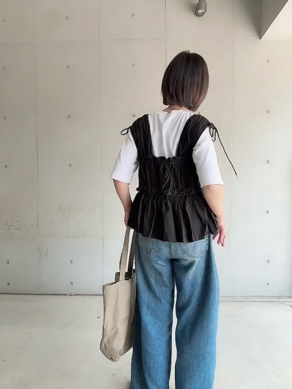 ブラック系のシャツ/ブラウス、ブルー系のデニムパンツ、ブラック系のパンプスを着用したレディースの夏コーディネートの3枚目の写真