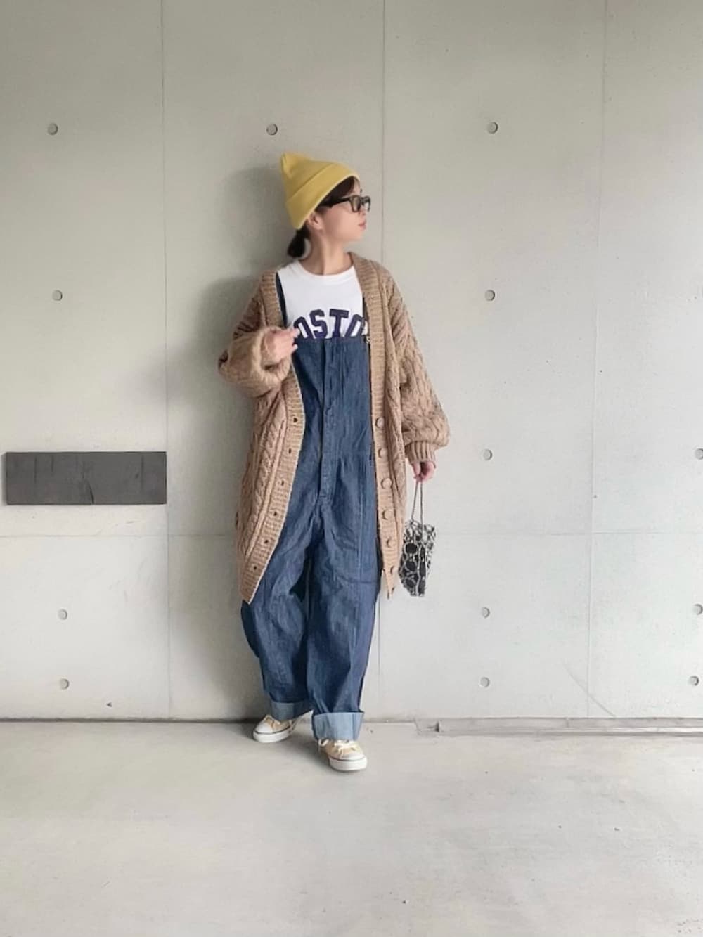 ブラウン系のカーディガン/ボレロ、ホワイト系のTシャツ/カットソー、ブルー系のサロペット/オーバーオールを着用したレディースの秋コーディネートの5枚目の写真