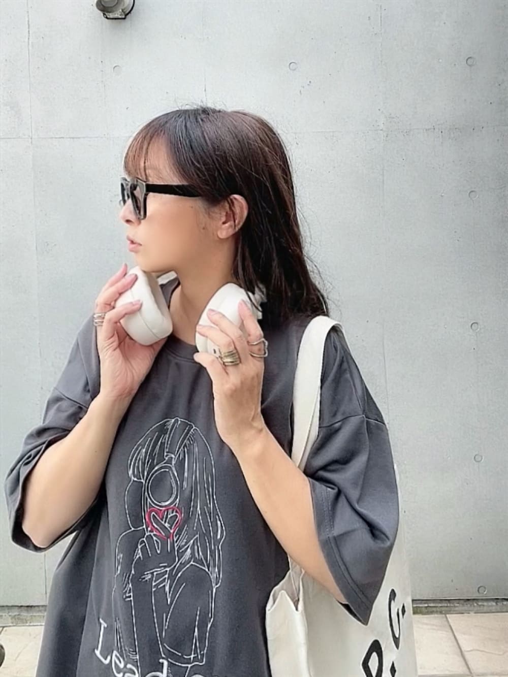 グレー系のTシャツ/カットソー、ホワイト系のトートバッグ、ベージュ系のサンダルを着用したレディースの夏コーディネートの3枚目の写真