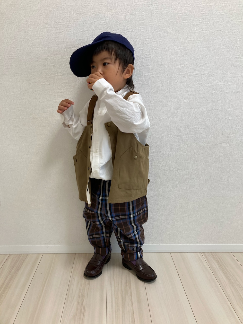 ホワイト系のシャツ/ブラウス、ベージュ系のベスト、ブラウン系のパンツを着用したキッズの秋コーディネートの2枚目の写真