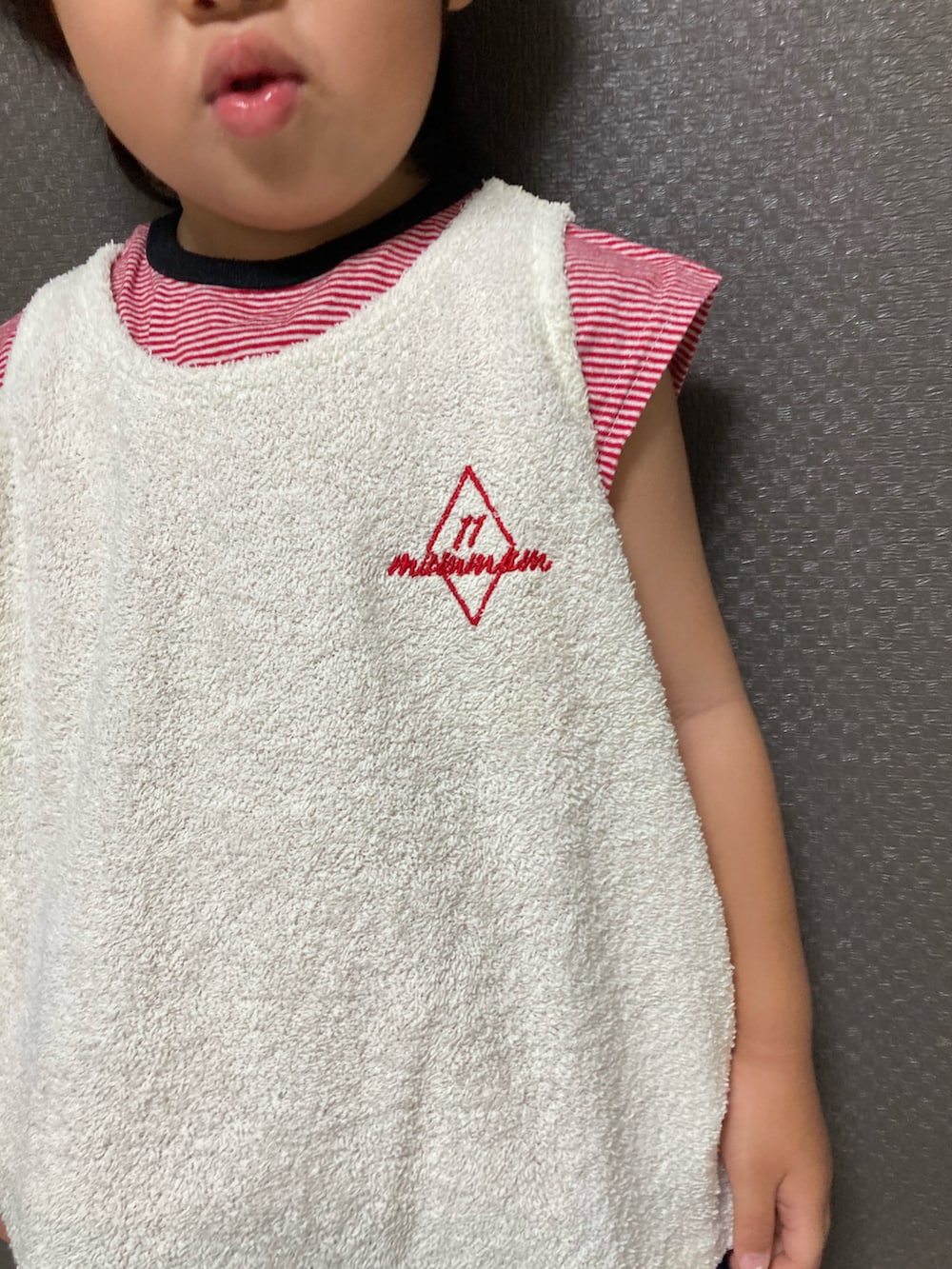 ホワイト系のタンクトップ、ブルー系のデニムパンツ、レッド系のスニーカーを着用したキッズの夏コーディネートの5枚目の写真
