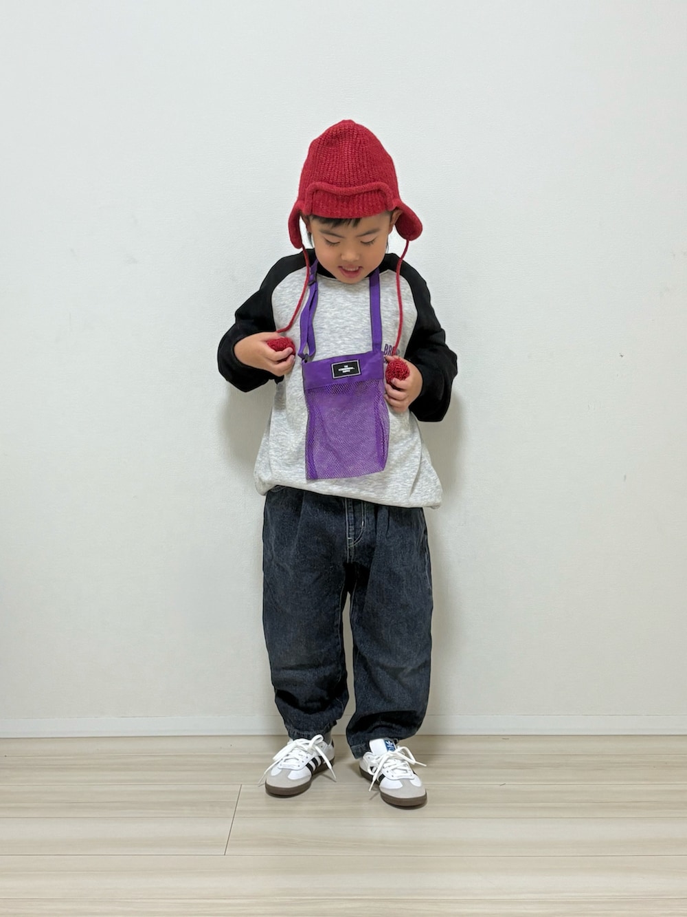 グレー系のスウェット、ブルー系のデニムパンツ、ホワイト系のスニーカーを着用したキッズの冬コーディネートの3枚目の写真