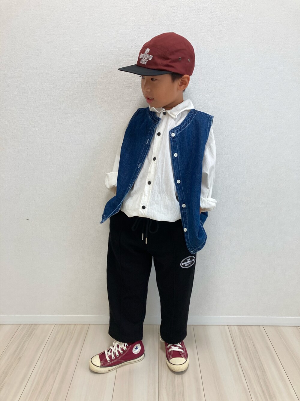 ホワイト系のシャツ/ブラウス、ブルー系のベスト、ブラック系のスウェットパンツを着用したキッズの秋コーディネートの2枚目の写真