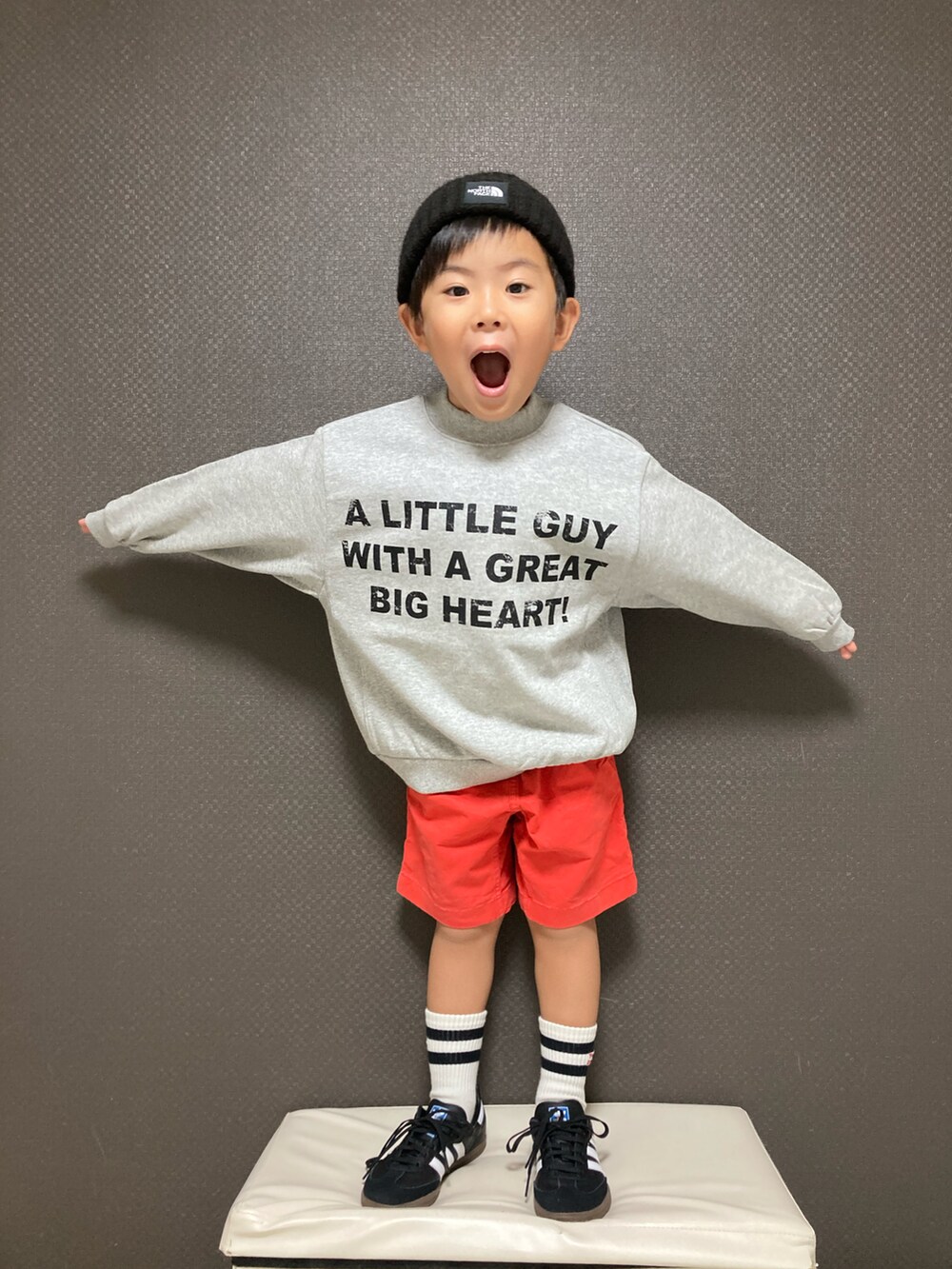 グレー系のスウェット、レッド系のその他パンツ、ブラック系のスニーカーを着用したキッズの秋コーディネートの3枚目の写真