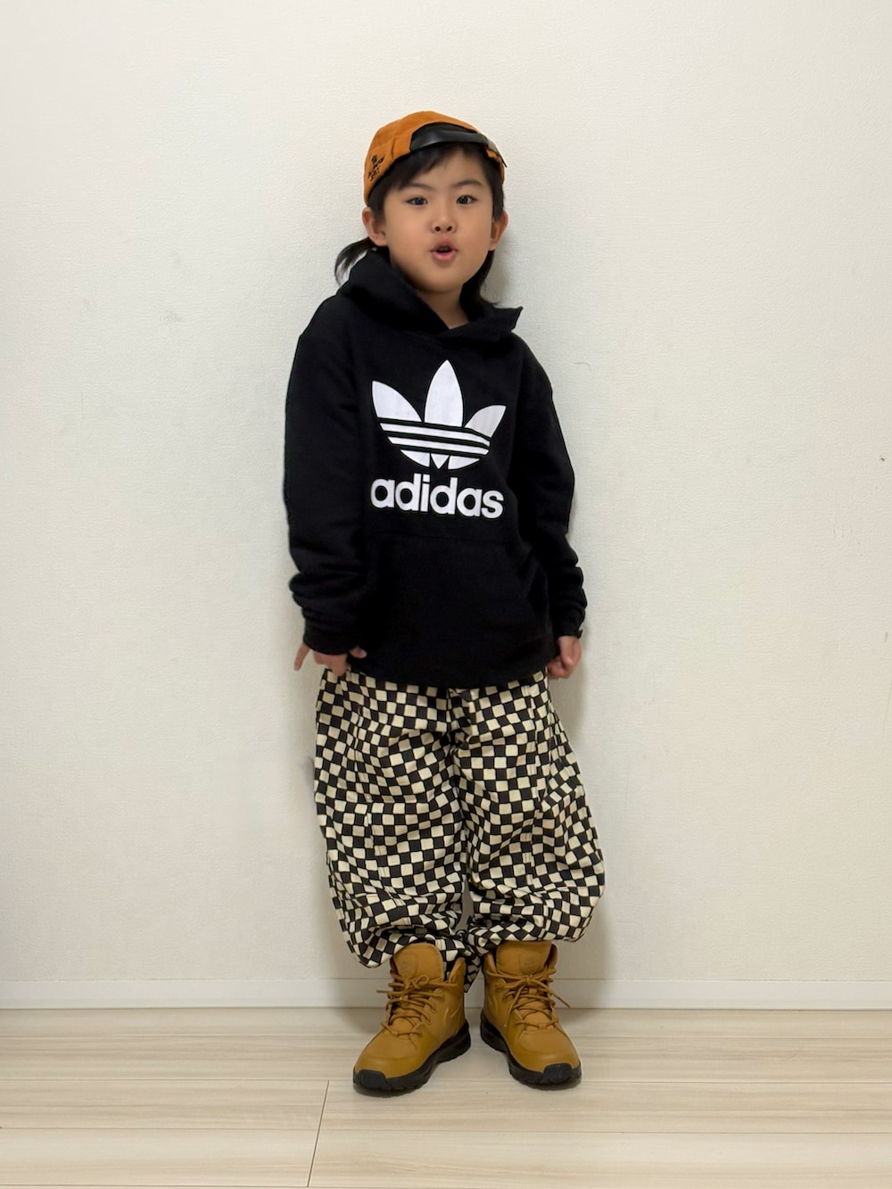 グレー系のその他パンツ、ブラウン系のスニーカー、ブラック系のパーカーを着用したキッズの春コーディネートの2枚目の写真