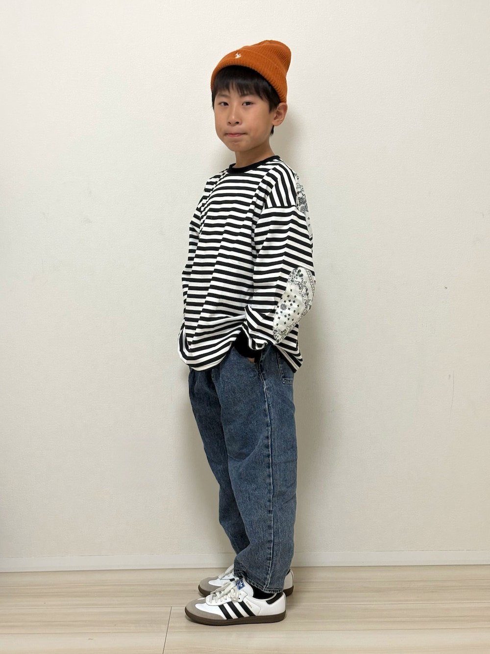 ブラック系のTシャツ/カットソー、ブルー系のデニムパンツ、ホワイト系のスニーカーを着用したキッズの春コーディネートの3枚目の写真