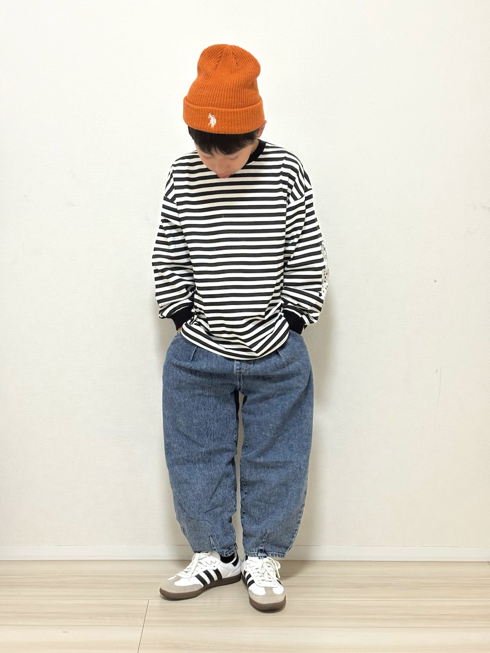 ブラック系のTシャツ/カットソー、ブルー系のデニムパンツ、ホワイト系のスニーカーを着用したキッズの春コーディネートの2枚目の写真